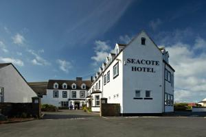 un edificio blanco con las palabras Scarcombe Hotel en él en Seacote Hotel, en St Bees