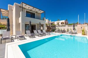 a swimming pool in front of a villa at Lagoon Seabreeze Villa, Sumptuous Retreat, By ThinkVilla in Panormos Rethymno