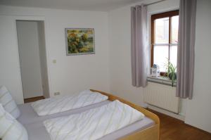 a bed in a room with a window and a bed sidx sidx sidx at Ferienwohnung St. Georg in Hemau