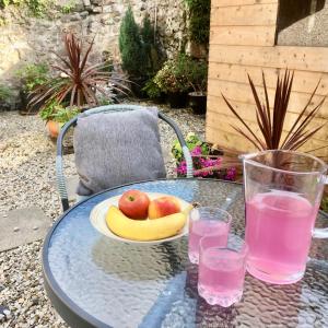een glazen tafel met een kom appels en een schaal fruit bij Chapel St Apartments in Caernarfon