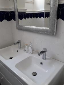 ein weißes Waschbecken im Bad mit Spiegel in der Unterkunft casa vacanze Vico Verona 7 in Oria
