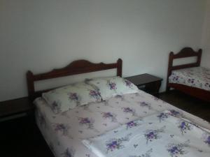 a bedroom with a bed with a floral bedspread at Complex Turistic Ocna Sibiului in Ocna Sibiului