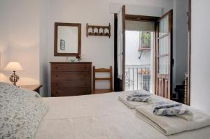 a bedroom with a bed and a dresser and a window at La Casita in Grazalema