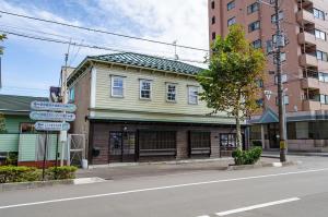 un edificio all'angolo di una strada cittadina di 箱館宿 観月-Mizuki-伝統的建築物の宿-最大8名宿泊可能 a Hakodate