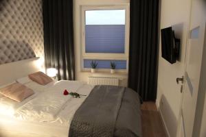Un dormitorio con una cama con una rosa. en Apartament Wspólna19 (Centrum, garaż podziemny, klimatyzacja ), en Kielce
