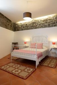 a bedroom with a white bed with pink pillows at Casa do Vale 2 in Peso da Régua