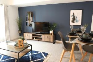 ein Wohnzimmer mit einem Tisch und einem TV in der Unterkunft Blueberry View-Wyndale-2BR Boutique Worcester in Worcester