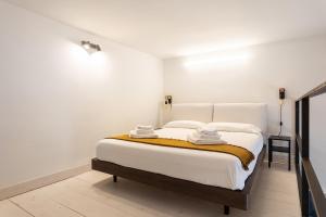una camera da letto con un grande letto e pareti bianche di Biancospino Suite by Wonderful Italy a Noto