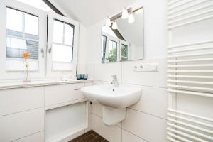 a white bathroom with a sink and a mirror at Appartement Lille Kamp 2 in Westerland +9 photos