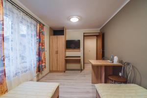 カルパチにあるU Musaのベッド、テーブル、テレビが備わる客室です。