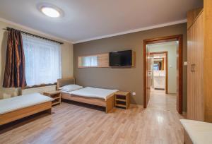 a room with two beds and a flat screen tv at U Musa in Karpacz