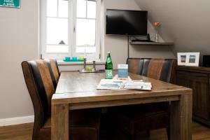 a wooden table with chairs and a bottle on it at Appartement Lille Kamp 2 in Westerland