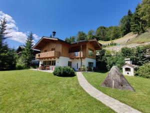 uma casa numa colina com um jardim de relva em Alpine Cottage Salzburg em Maria Alm am Steinernen Meer