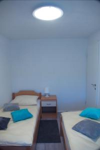 Habitación con 2 camas y mesa con lámpara. en Apartmaji Anita, en Begunje pri Cerknici