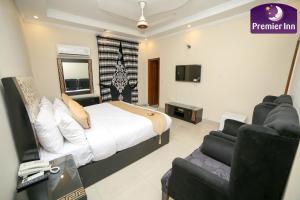 ein Schlafzimmer mit einem Bett, einem TV und einem Sofa in der Unterkunft Premier Inn Grand Gulberg Lahore in Lahore