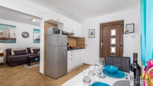 a kitchen and living room with a table and a refrigerator at Apartment Follow Me in Opatija