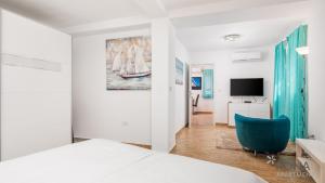 a bedroom with a bed and a blue chair at Apartment Follow Me in Opatija