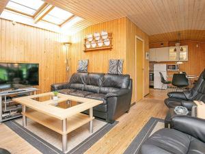 ein Wohnzimmer mit einem Ledersofa und einem Couchtisch in der Unterkunft 6 person holiday home in Dannemare in Dannemare