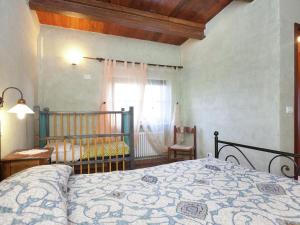 a bedroom with a bed and a crib and a window at Farmhouse in Apecchio with Swimming Pool Terrace Garden BBQ in Apecchio