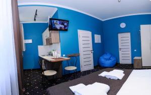 ein Schlafzimmer mit blauen Wänden, einem Waschbecken und einem Schreibtisch in der Unterkunft Luxury.ap in Iwano-Frankiwsk