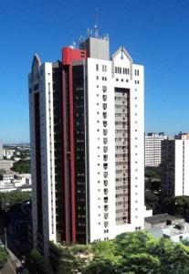 un gran edificio blanco con acentos rojos en una ciudad en Golden Ingá Hotel en Maringá