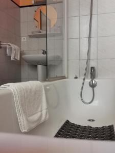 La salle de bains blanche est pourvue d'une baignoire et d'un lavabo. dans l'établissement La Table Des Bons Peres, à Bislée