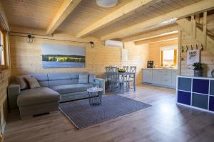 a living room with a couch and a kitchen at Dadaj Summer Camp - całoroczne domki Rukławki in Biskupiec