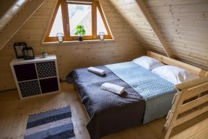 ein Schlafzimmer mit einem Bett in einem Blockhaus in der Unterkunft Dadaj Summer Camp - całoroczne domki Rukławki in Biskupiec