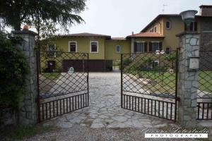 a gate to a yard with a house at B&B Barbettini in Bereguardo