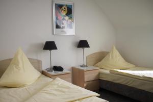 ein Zimmer mit zwei Betten und zwei Lampen auf Tischen in der Unterkunft Hotel Central in Erlangen