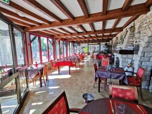 a restaurant with tables and chairs and a stone wall at La Table Des Bons Peres in Bislée