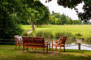 three park benches sitting next to a body of water at The Lion in Leintwardine