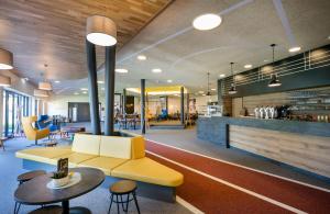 a lobby with a couch and a table and chairs at JUFA Hotel Erlaufsee in Mariazell