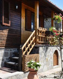 a wooden house with a staircase and a flower pot at Baita La Stradella in Serravalle
