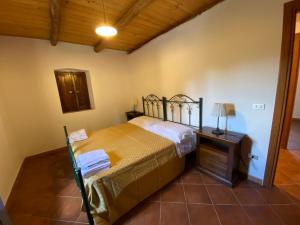 ein Schlafzimmer mit einem Bett und einem Tisch mit einer Lampe in der Unterkunft Agriturismo Tenuta Feraudo in Labonia