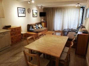 uma sala de estar com uma mesa e um sofá em Residence Aldebaran - maeva Home em Flaine