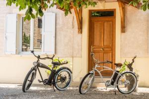 twee fietsen geparkeerd voor een gebouw bij LA DOLOREANNE in Saint-Didier-sur-Chalaronne