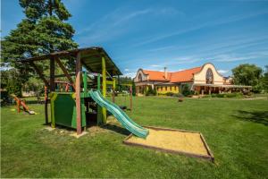 a playground with a slide in a yard at Wellness hotel Spark in Malacky