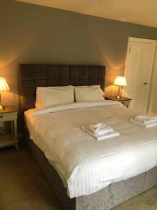 a bedroom with a large bed with two lamps at Queen Street Apartments in Enniskillen