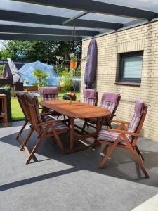 a wooden table and chairs with purple chairs around it at Nordsee-Koje in Brunsbüttel