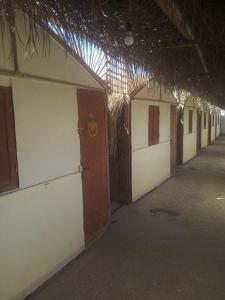 Elbadawy camp في Nuweiba: مبنى فارغ مع صف من الابواب وسقف