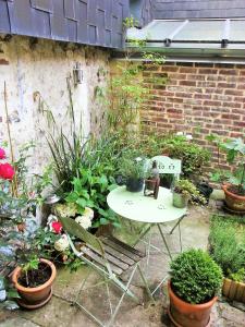 une table et des chaises dans un jardin avec des plantes dans l'établissement My Little Garden -Parking gratuit 500m -Coeur historique -La Clef de Honfleur, à Honfleur