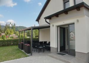 a house with a patio with a table and chairs at Apartmaji Anita in Begunje pri Cerknici