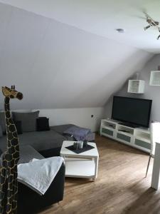 a living room with a couch and a giraffe head on the wall at Nordsee-Koje in Brunsbüttel