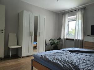 a bedroom with a bed and a chair and a window at Nordsee-Koje in Brunsbüttel +19 photos