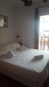 a large white bed in a room with a window at Los Estribos in Zahara de la Sierra