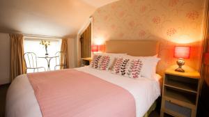 1 dormitorio con cama, mesa y ventana en Hollybush Inn en Greenhaugh