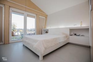 a white bedroom with a bed and a large window at Quinta Da Fontinha in Celorico de Basto