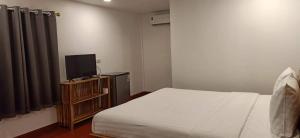a bedroom with a bed and a flat screen tv at King Fa House in Mae Sot