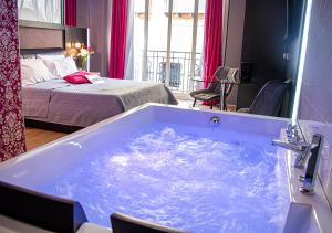 拿坡里的住宿－安吉尼奧Spa酒店，一张床铺的房间里设有一个大型蓝色浴缸